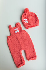 Various colors and types of cotton clothing, knitted newborn clothes and newborn hats on a white background.
