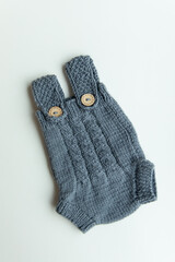 Various colors and types of cotton clothing, knitted newborn clothes and newborn hats on a white background.