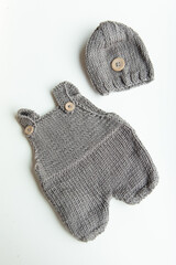 Various colors and types of cotton clothing, knitted newborn clothes and newborn hats on a white background.