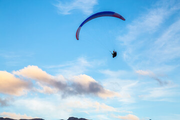 Paraglider flying Up High surrounded by Clouds in Canadian Nature. Taken in Tombstone Territorial Park, Yukon, Canada.
