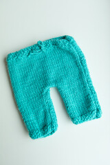 Various colors and types of cotton clothing, knitted newborn clothes and newborn hats on a white background.