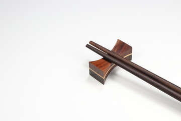 Classic wooden chopstick with stand isolated on the white background. Famous kitchenware in Chinese restaurant. 