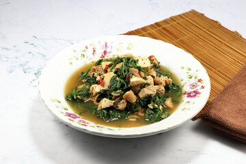 Fried and stirred spicy fresh Paco Fern with tofu, chilly and basil on the plate. Famous hot and spicy vegetarian menu in Asia restaurant. 