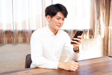 部屋でスマホを使う男性
