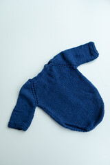 Various colors and types of cotton clothing, knitted newborn clothes and newborn hats on a white background.