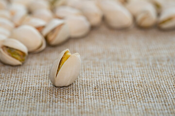 Pistachio nuts on brown sack background. Healthy food high protein.