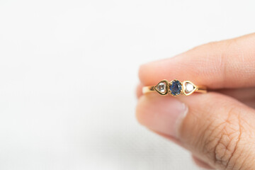 Man holding wedding ring over white background.