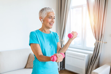 Senior woman exercise with dumbbells at home . happy mature woman doing arm workout using dumbbells. Elderly woman prefers healthy lifestyle