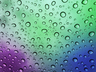 Image of water droplets on a multicolor surface during heavy rain.