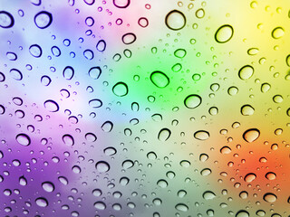 Image of water droplets on a multicolor surface during heavy rain.