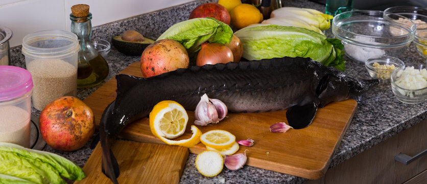 Picture of raw fish sturgeon at plate before preparing laying on table
