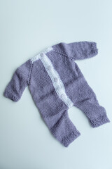 Various colors and types of cotton clothing, knitted newborn clothes and newborn hats on a white background.