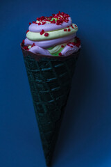 Ice cream cone on a plate. The combination of lemon ice cream and strawberry sorbet with pieces of fragrant raspberries.