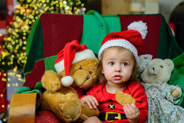 Fototapeta na wymiar Little baby in Santa hat celebrates Christmas. Infant in New Year cap.