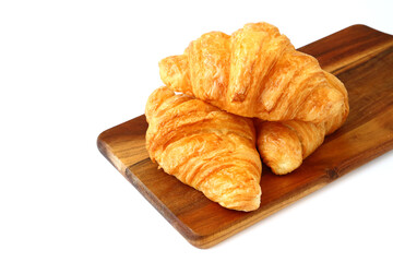 homemade croissants on wooden cutting board isolated on white background