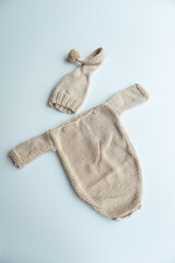 Various colors and types of cotton clothing, knitted newborn clothes and newborn hats on a white background.