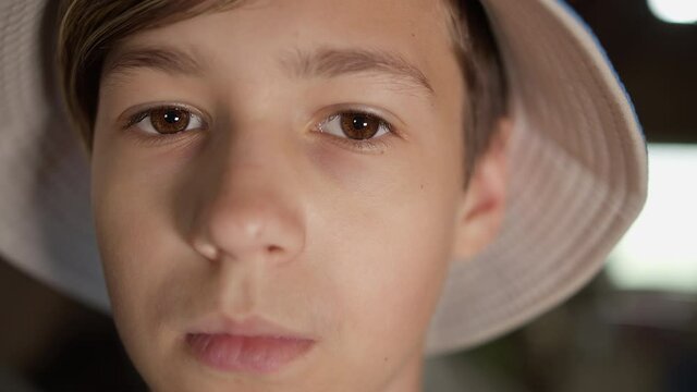 portrait of a serious scared boy in a hat looking at the camera indoors