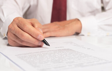 Contract signing concept. Businessman hand with pen over document closeup