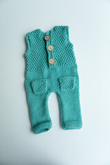 Various colors and types of cotton clothing, knitted newborn clothes and newborn hats on a white background.