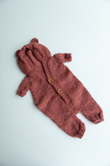 Various colors and types of cotton clothing, knitted newborn clothes and newborn hats on a white background.