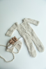 Various colors and types of cotton clothing, knitted newborn clothes and newborn hats on a white background.