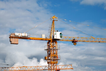 Construction crane on a blue cloudy sky background