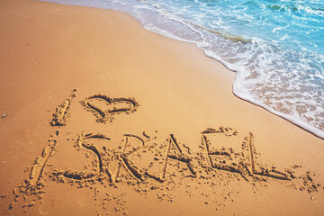 Fototapeta na wymiar The words I love Israel on the beach sand. Inscription I love Israel on seashore with wave