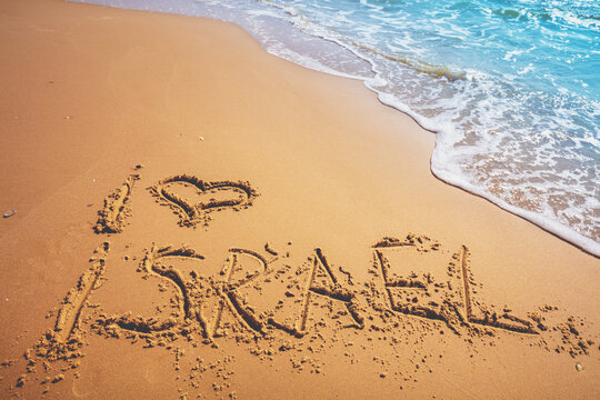 The words I love Israel on the beach sand. Inscription I love Israel on seashore with wave