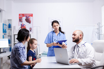 Doctor holding pills bottle during child consultation in home office. . Healthcare physician specialist in medicine providing health care services treatment examination.