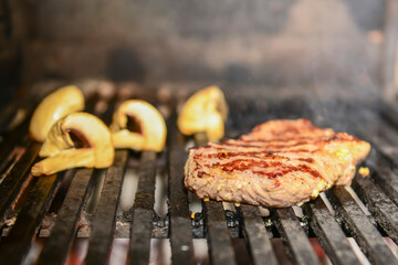 Assorted meat from pork and mushrooms vegetables on barbecue grill cooked for summer family dinner