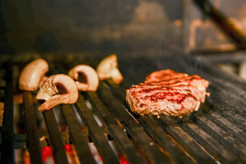 Assorted meat from pork and mushrooms vegetables on barbecue grill cooked for summer family dinner