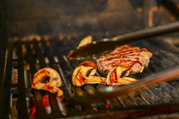 Assorted meat from pork and mushrooms vegetables on barbecue grill cooked for summer family dinner