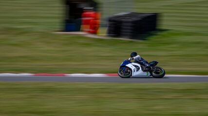 A panning shot of a racing bike cornering on a track.