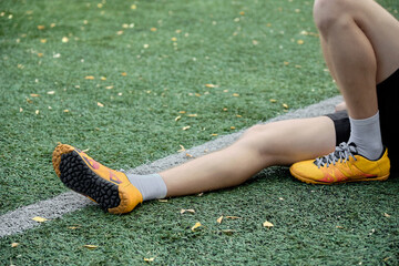 feet of soccer player in yellow shoes on green soccer field