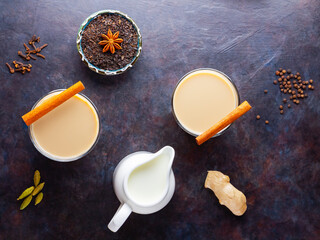 Masala chai tea. Traditional indian drink - masala tea with various spices. Two glasses with masala tea on a dark background