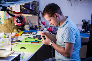 man cleans a laptop with a special tool from dust. Repair and maintenance of laptops and PCs Advertising services for the repair of electronics and devices.