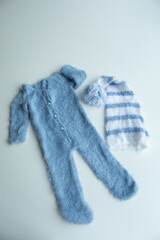 Various colors and types of cotton clothing, knitted newborn clothes and newborn hats on a white background.