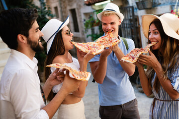Group of friends eating pizza while traveling on vacation
