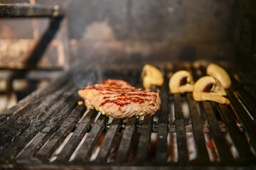 Assorted meat from pork and mushrooms vegetables on barbecue grill cooked for summer family dinner