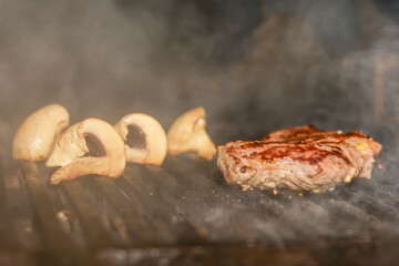 Assorted meat from pork and mushrooms vegetables on barbecue grill cooked for summer family dinner