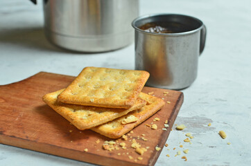 Cracker and coffee on the wooden chopping board on the table