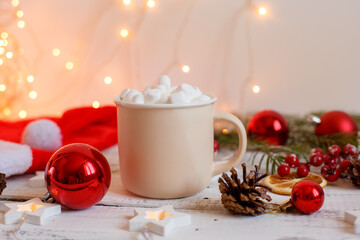 Christmas background,  coffee mug and marshmallows , red Christmas toys, glowing lights . Merry Christmas greeting card