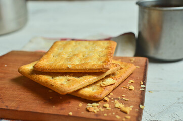 Cracker and coffee on the wooden chopping board on the table