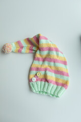Various colors and types of cotton clothing, knitted newborn clothes and newborn hats on a white background.