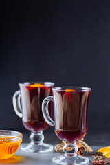 Mulled wine on a slate board. Two glasses of hot mulled wine and ingredients. Christmas hot drink with wine and honey