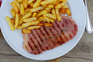 tranche de jambon grillé et frites dans une assiette