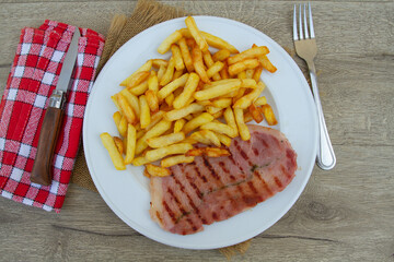 tranche de jambon grillé et frites dans une assiette