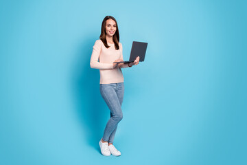 Full length body size profile side view of her she nice attractive pretty cheerful girl holding in hands using laptop browsing web isolated over bright vivid shine vibrant blue color background