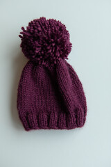 Various colors and types of cotton clothing, knitted newborn clothes and newborn hats on a white background.