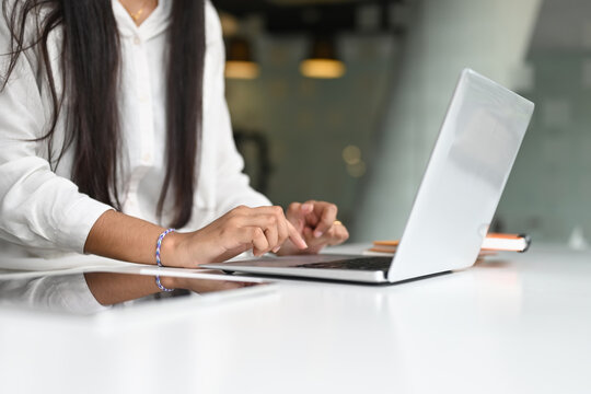 Cropped Shot Of Young Female Free Lancer Hands Typing On Computer Laptop On White Desk.